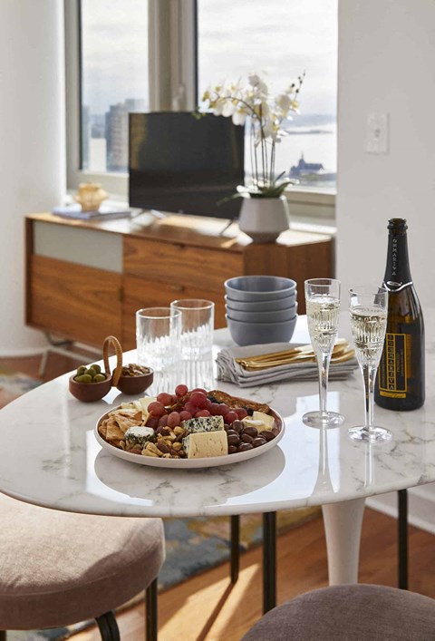 a table with a plate of food and wine on it