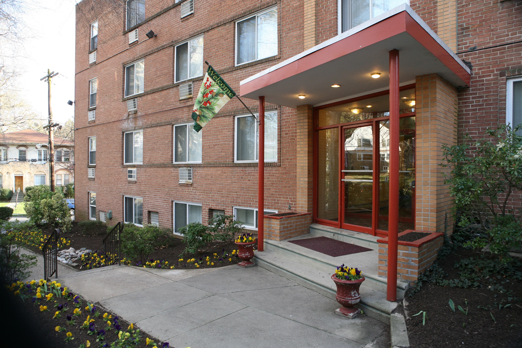 Exterior of building showing entrance, walkway, and gardens.