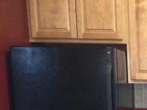 Kitchen with granite counter tops, black appliances and tile backslash