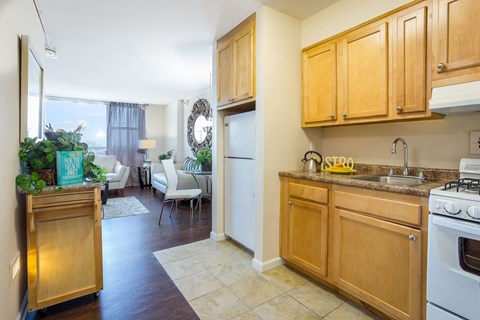 Kitchen equipped with granite counter tops and white appliances. opens into living room.