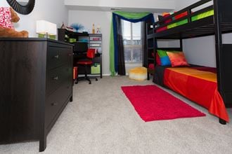 Furnished bedroom with gray carpeting and window
