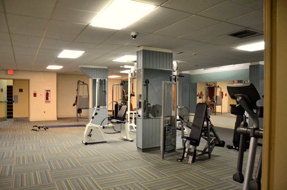 Fitness center equipped with elliptical, weight lifting machines, and indoor exercise bike.