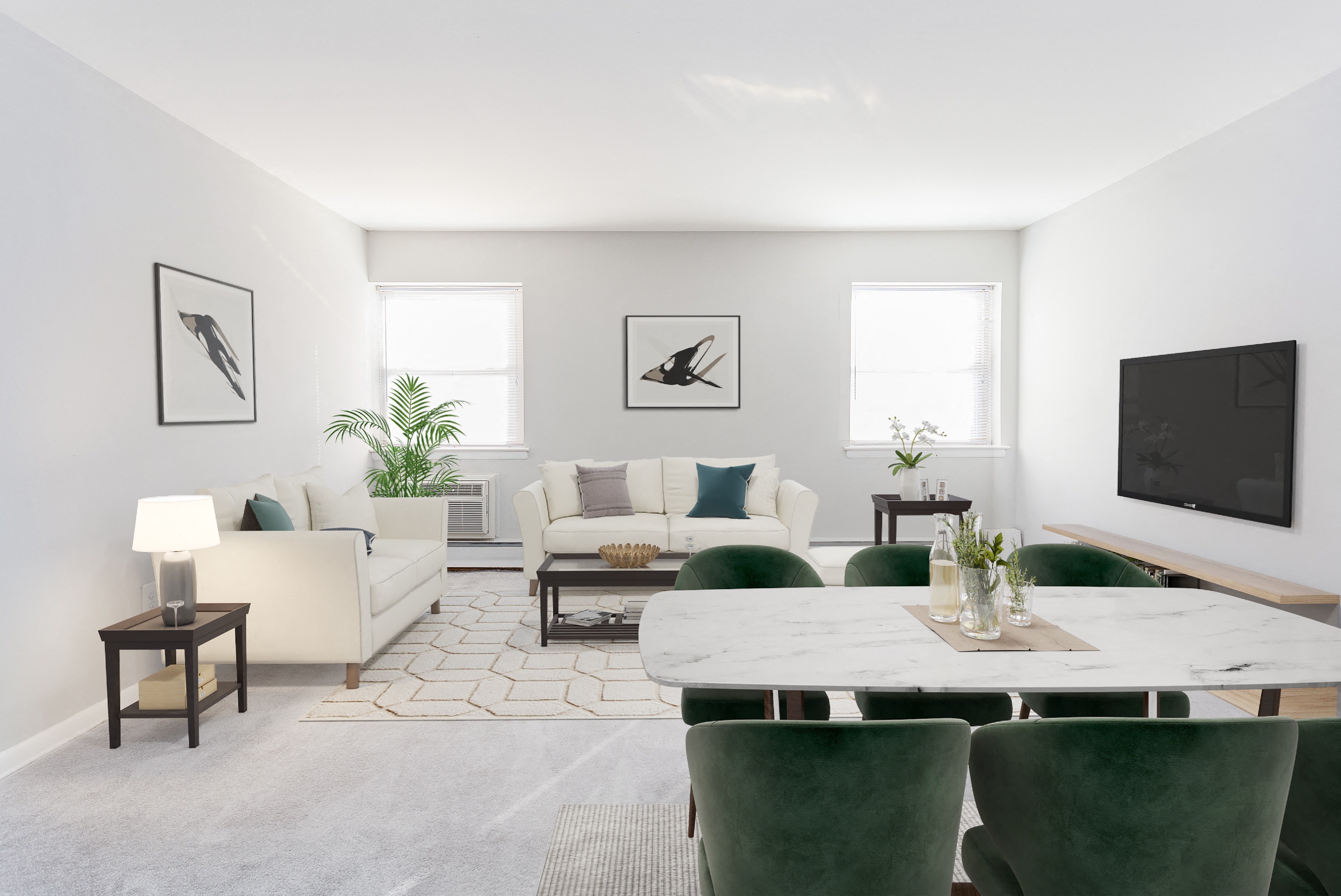 a living room with a white couch and a table and green chairs