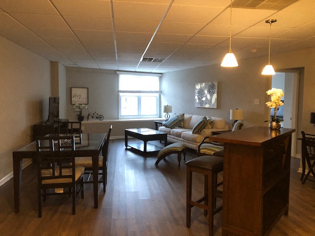 A living room with a couch, chairs, and a dining table.