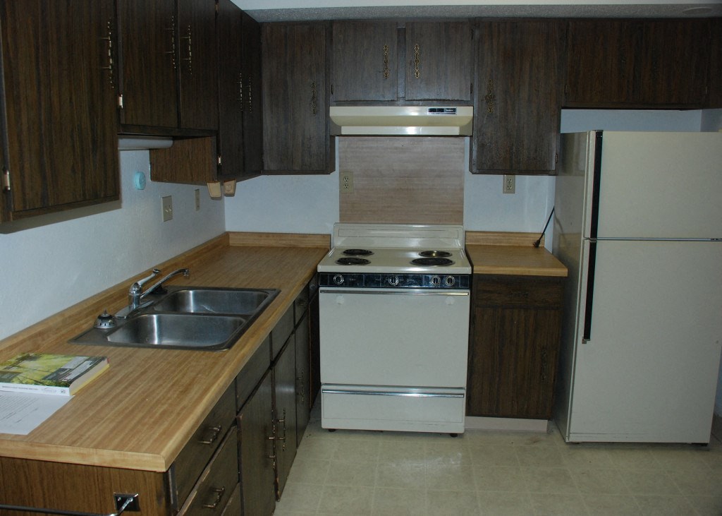 an empty kitchen with a stove and a sink