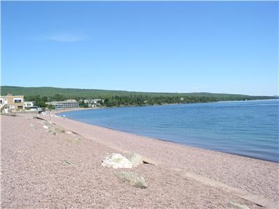a beach with a large body of water and some rocks