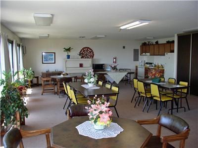 a large room with tables and chairs and a kitchen