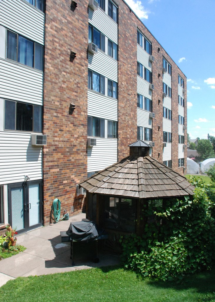 an outdoor gazebo in front of an apartment building