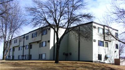 an apartment building with a tree in front of it