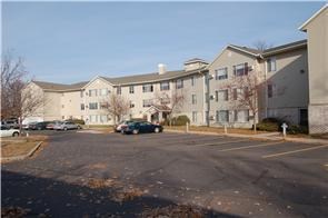 an empty parking lot in front of an apartment building