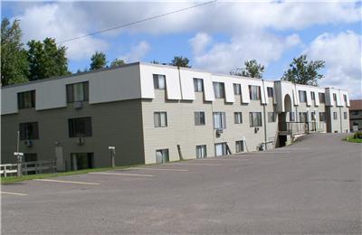 a row of apartment buildings with a parking lot
