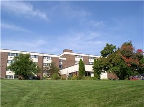 a large brick building in the middle of a field