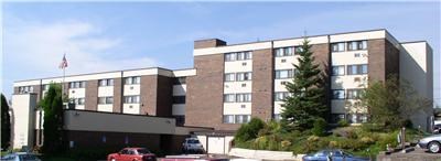 an apartment building with a parking lot with cars