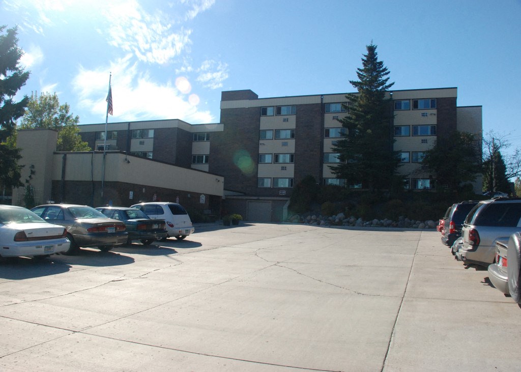 a parking lot with cars in front of a large building
