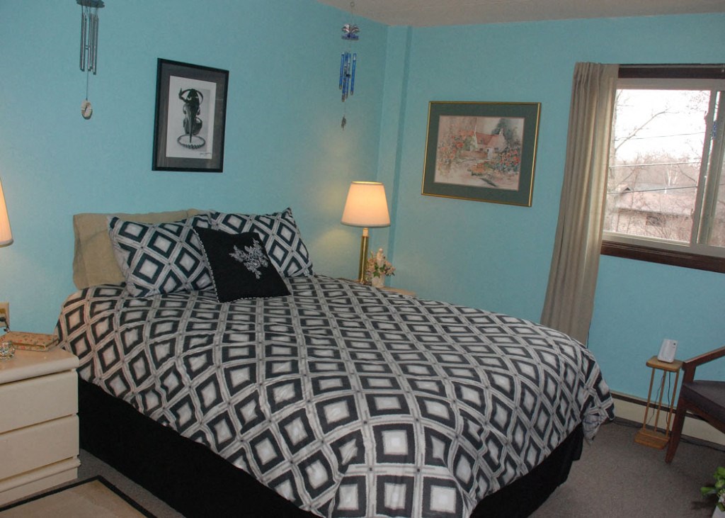 a black and white bed in a room with blue walls