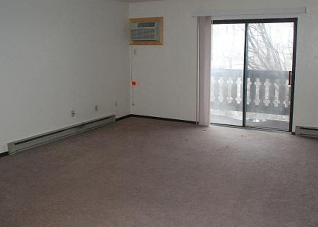 an empty living room with a sliding glass door