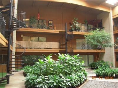 an apartment building with plants in the courtyard
