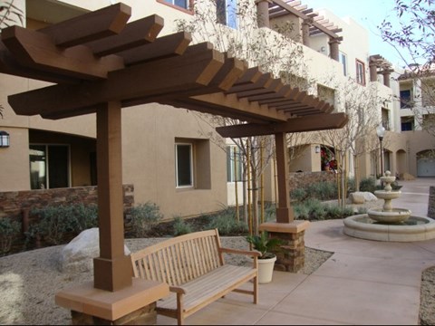 a wooden bench sitting under a wooden canopy