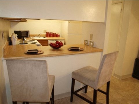 a kitchen with a counter and two chairs