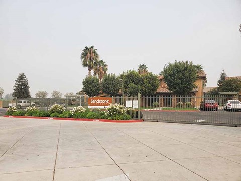 a parking lot in front of a building with palm trees