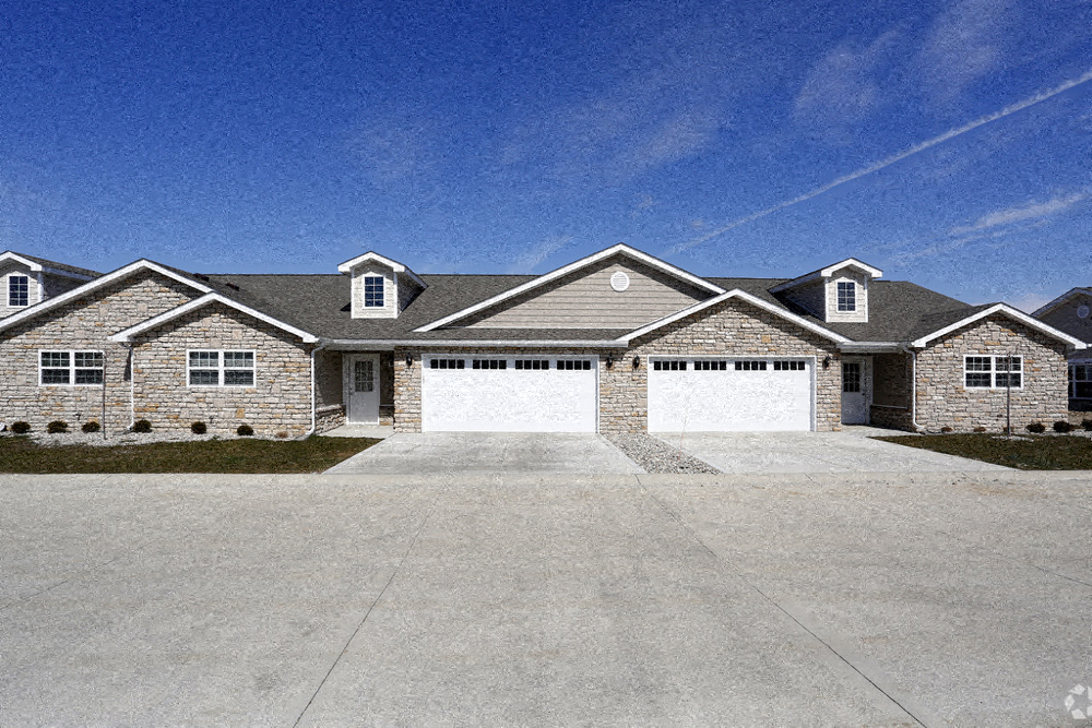 A large house with a grey roof and a white garage door.