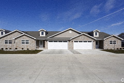 A large house with a grey roof and a white garage door.