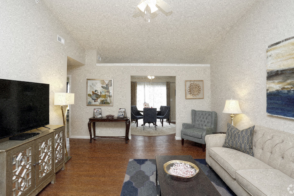 A living room with a grey couch, a coffee table, and a television.
