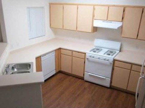 an empty kitchen with a stove and a sink