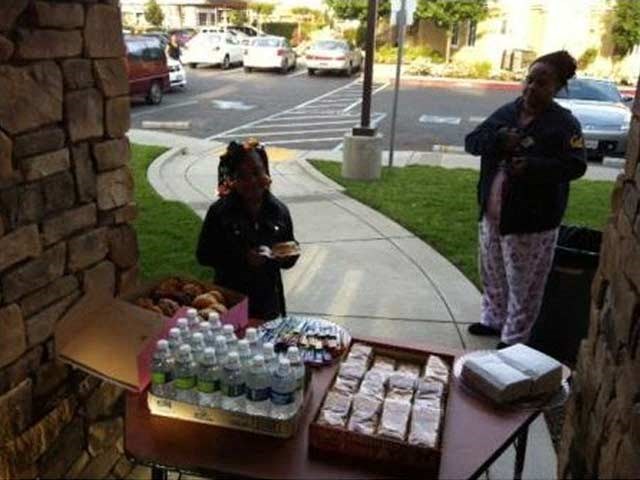 two women standing near a table with food on it
