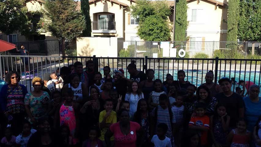 a group of people standing in front of a fence