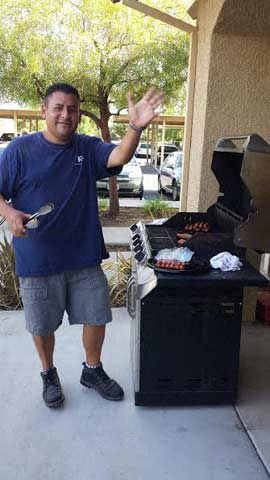 a man is standing in front of a grill