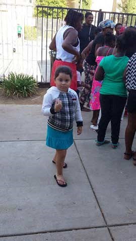 a little girl walking down a sidewalk