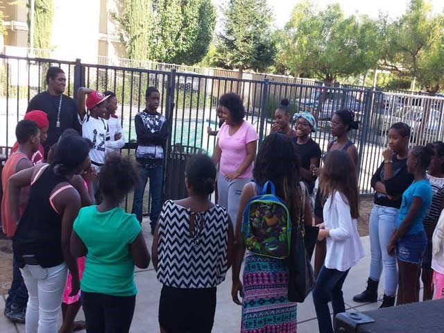 a group of people standing in front of a fence