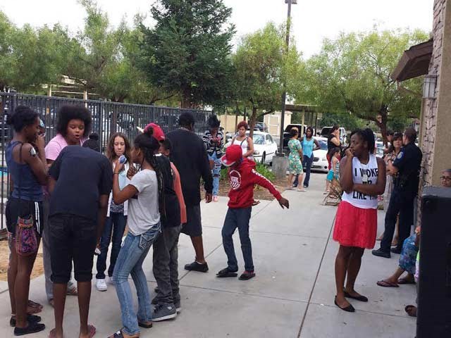 a group of people standing on a sidewalk