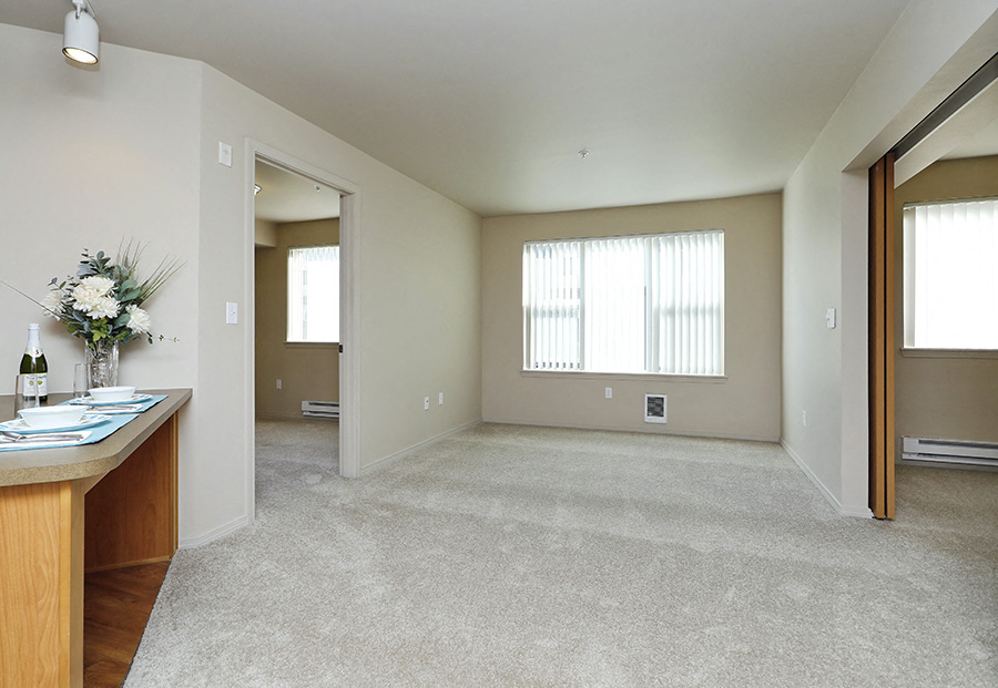 A spacious living room with a dining table and chairs.