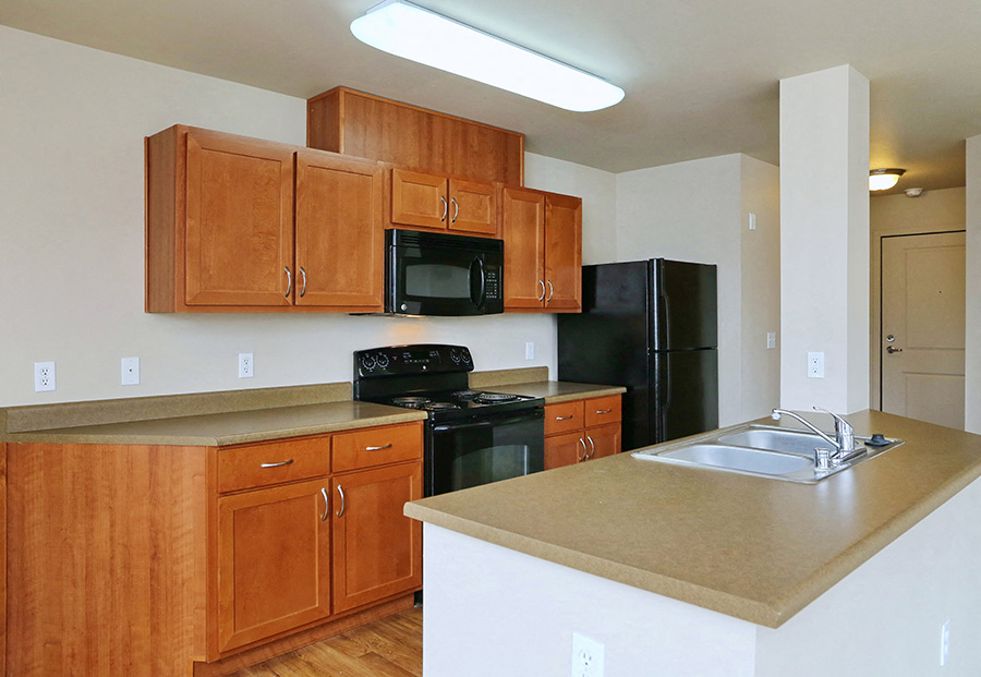 A kitchen with wooden cabinets and black appliances.
