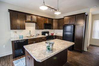 a kitchen with dark wood cabinets and a granite counter top
