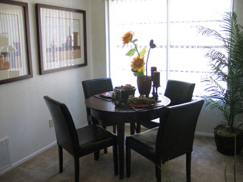 A dining room with a table set for four.