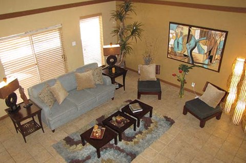 A living room with a grey couch, a coffee table, and a painting on the wall.