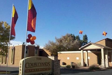 The Courtyards Apartments sign is in front of a building.