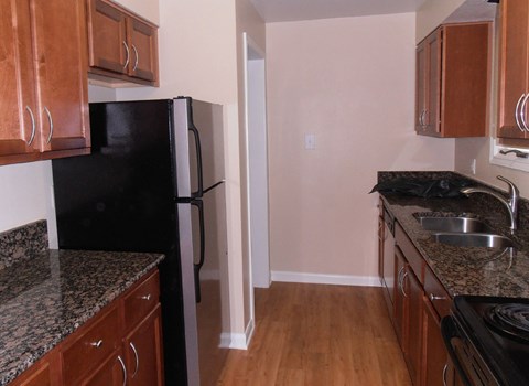 a kitchen with wood cabinets and a black refrigerator