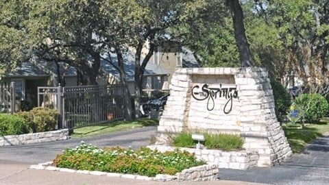 a stone monument with graffiti on it in front of a street