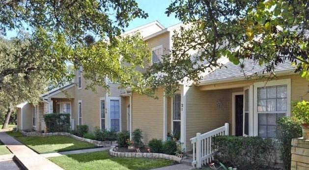 a yellow house with a white fence in front of it