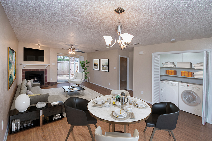 a living room and dining room with a washer and dryer and a kitchen