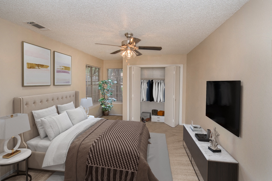 a bedroom with a large bed and a ceiling fan