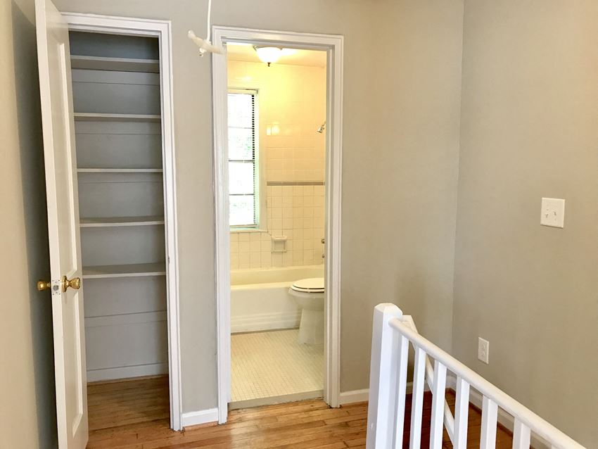 a small bathroom with a door open to a shower and a toilet