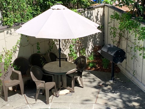 a patio with a table and chairs under an umbrella