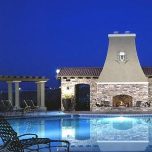 Roseville Apartments-The Phoenician Apartments Pool With Mediterranean Style Architecture And Lounge Chairs And BBQ Grills
