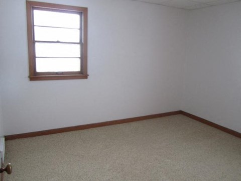 an empty room with a window and a carpet