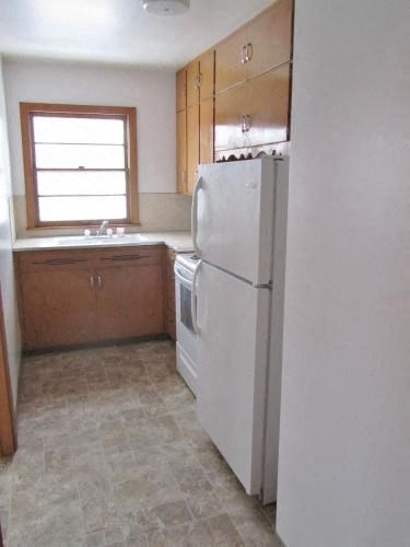 a kitchen with a white refrigerator and a window